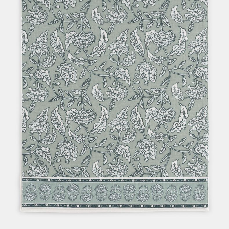 Close-up of the Kilburn & Scott Table Runner, featuring a heritage-inspired floral and bird pattern in soft sage green and white. Intricate botanical details and a decorative border create a timeless country-style design, while the woven fabric adds textu
