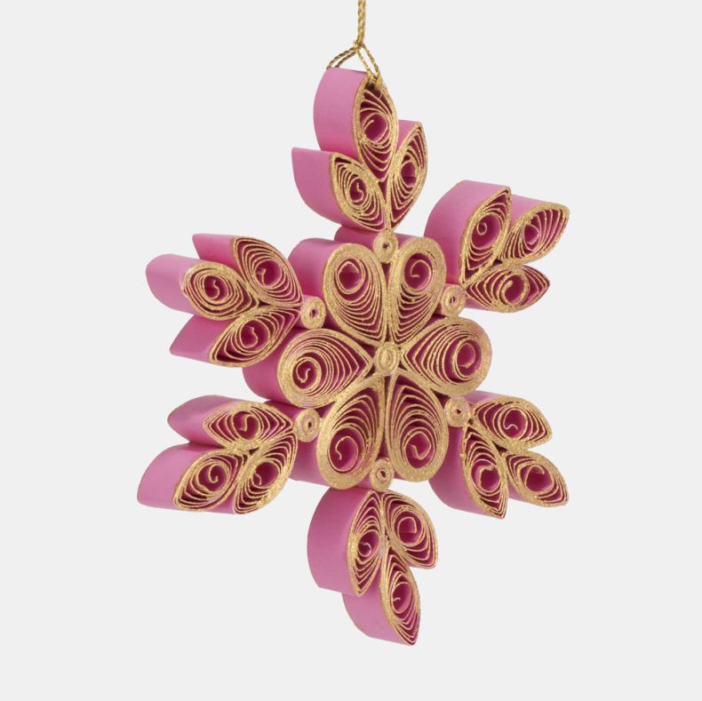 Pink and gold quilled paper snowflake Christmas hanging decoration shown from an angled close-up view, featuring intricate hand-rolled paper filigree detailing, layered six-point snowflake design, gold-edged scrollwork, dimensional construction, jewel-eff