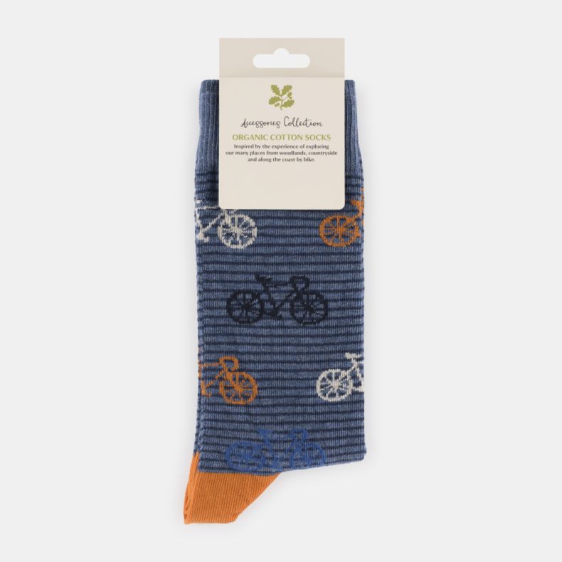 Blue striped organic cotton socks with navy, white and orange bicycle motifs, featuring a blue marl background, fine horizontal stripe pattern, and contrasting orange heel and toe, displayed folded with retail packaging.