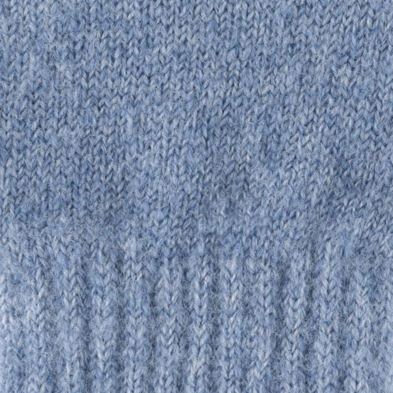Light blue knitted glove fabric shown in a close-up view, highlighting the soft fuzzy texture, fine marl knit construction, and ribbed cuff detailing.