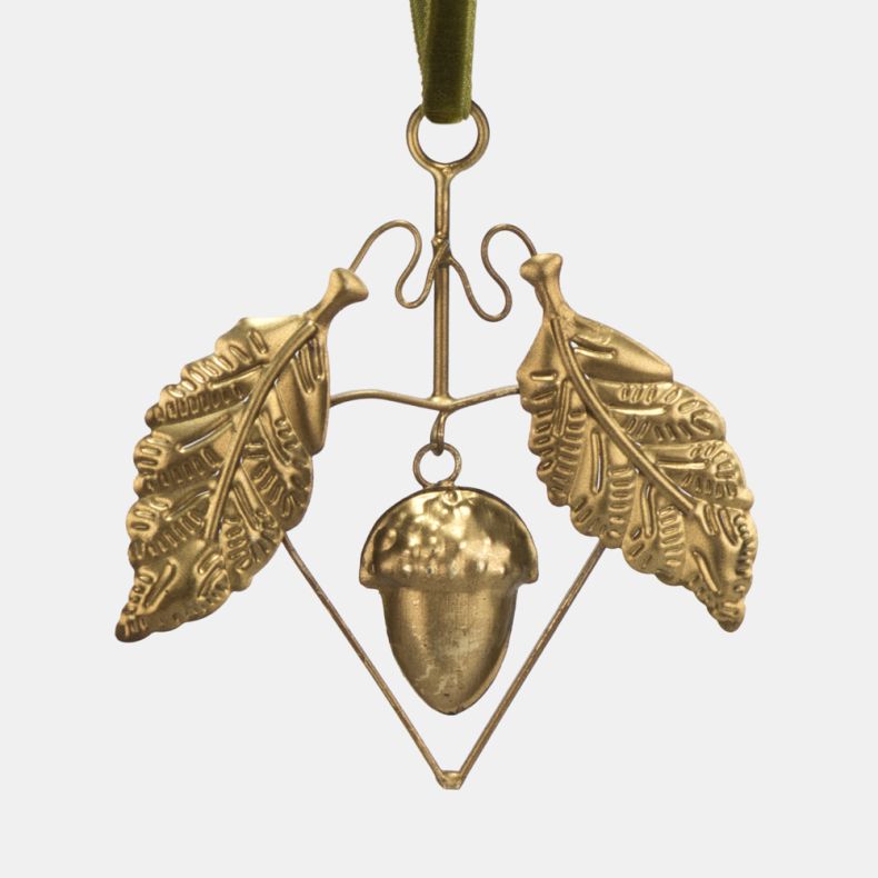 Gold-tone hanging acorn decoration shown in a close-up view, featuring detailed oak leaf motifs, a textured acorn charm, geometric wire frame detailing, and an olive green velvet hanging ribbon with an antique brass-effect finish.
