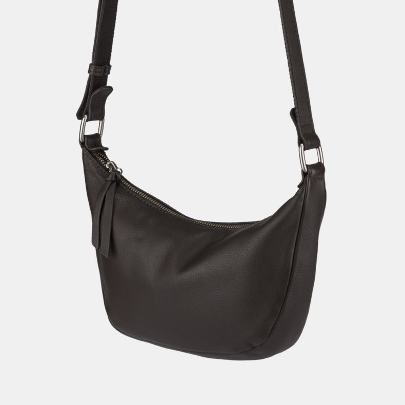 Dark brown leather-look crescent shoulder bag shown in a close-up view, highlighting the pebbled texture, zip-top closure with pull tab, adjustable strap, and silver-tone hardware.