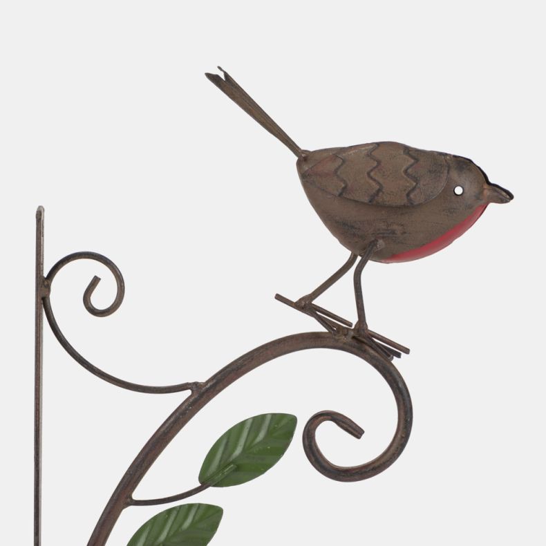 Close-up side view of a decorative metal robin wall bracket with a rustic brown finish and bright red breast. The robin perches on a curved scrollwork arm with green leaf accents, designed for hanging baskets, lanterns, or other garden decorations.