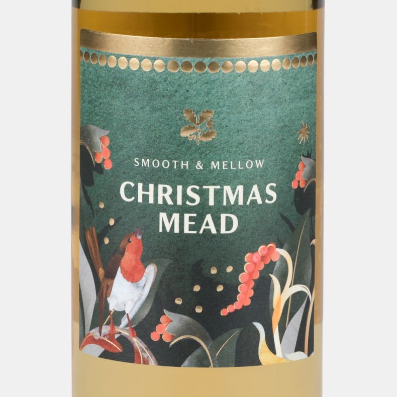 Close-up of the Christmas mead bottle label featuring a robin, winter foliage, red berries and the text “Smooth & Mellow Christmas Mead”.