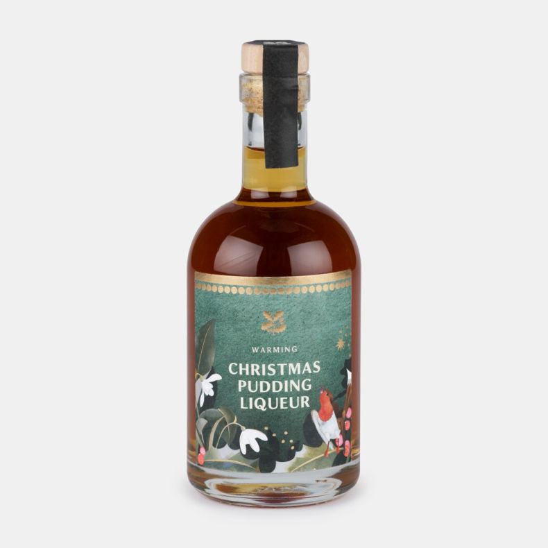 Bottle of warming Christmas pudding liqueur with a festive illustrated label featuring a robin, winter foliage and berries, presented on a light grey background.
