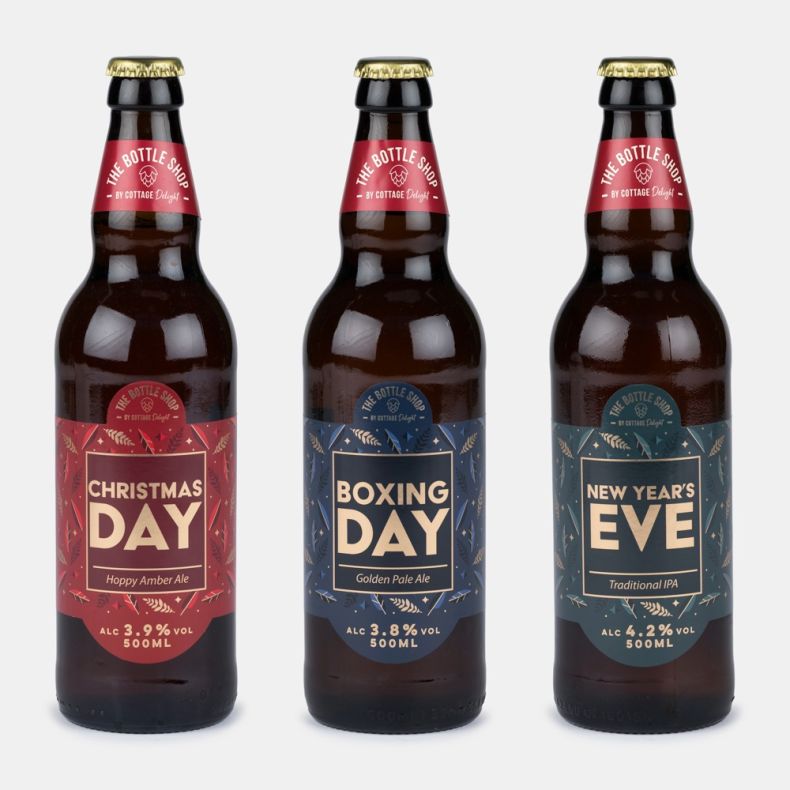 Three bottled festive ales including Christmas Day Hoppy Amber Ale, Boxing Day Golden Pale Ale and New Year's Eve Traditional IPA, displayed side by side with decorative seasonal labels.