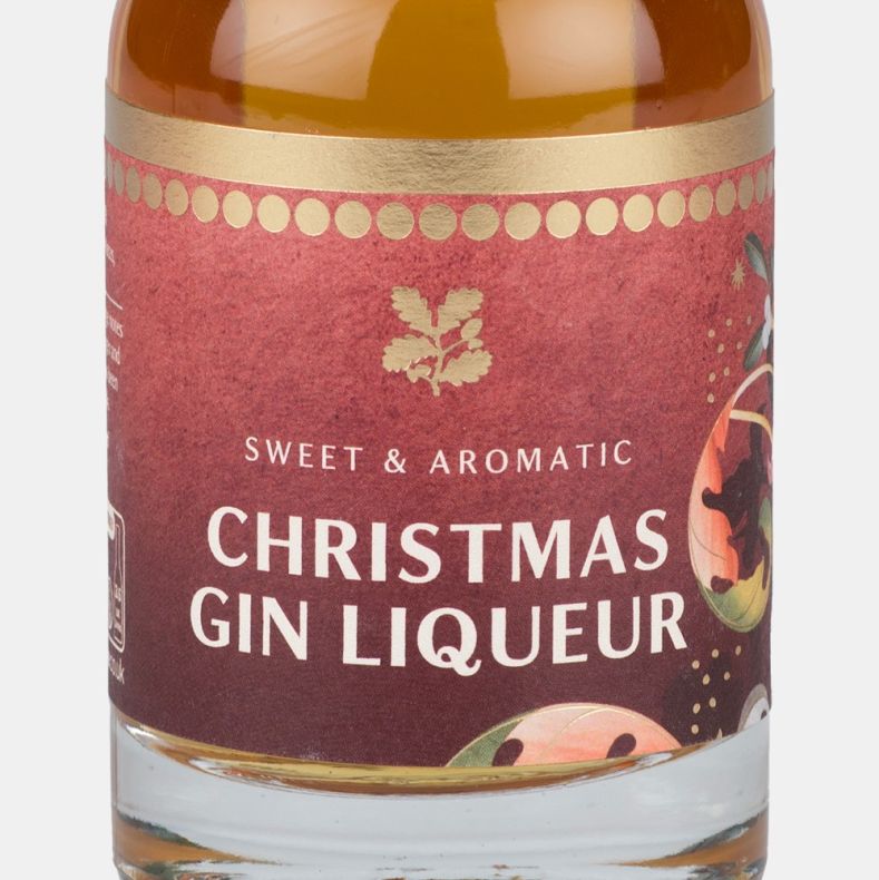 Close-up of a Christmas gin liqueur bottle label featuring festive botanical illustrations and the text “Sweet & Aromatic Christmas Gin Liqueur”.