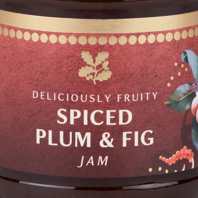 Close-up of a spiced plum and fig jam jar label featuring festive botanical illustrations and the text “Deliciously Fruity Spiced Plum & Fig Jam”.
