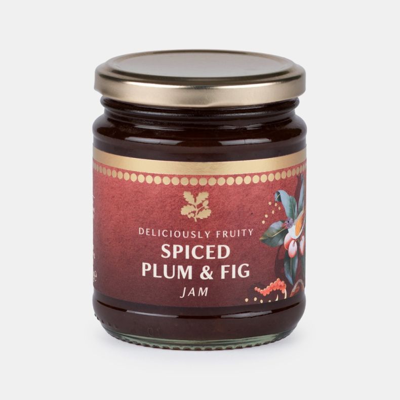 Jar of spiced plum and fig jam with a festive burgundy label featuring seasonal botanical illustrations and the text “Deliciously Fruity Spiced Plum & Fig Jam”.