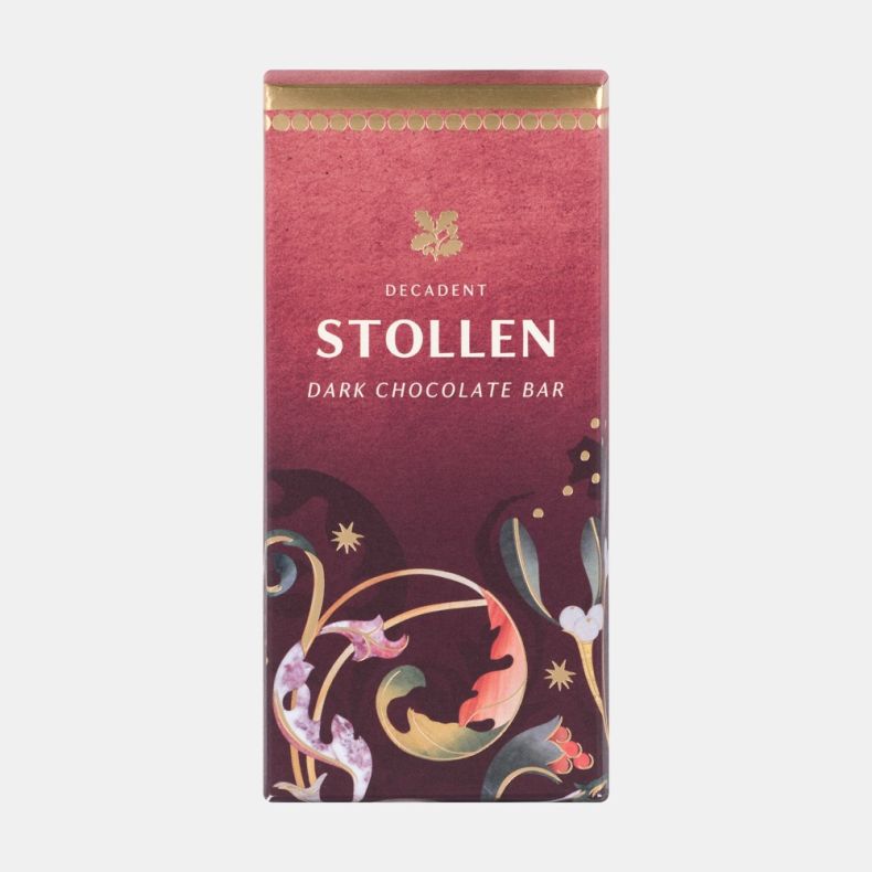 Decadent Stollen dark chocolate bar in festive red packaging with gold accents and decorative seasonal botanical illustrations, shown front on.