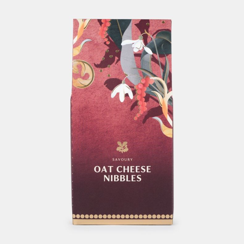 Savoury oat cheese nibbles in festive burgundy packaging with gold accents and decorative seasonal botanical illustrations, shown front on.