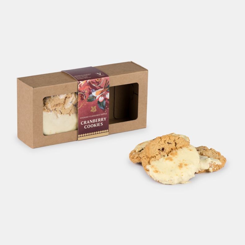 Yoghurt flavoured dipped cranberry cookies in a kraft gift carton with a festive illustrated sleeve, displayed alongside three white chocolate dipped cranberry cookies.