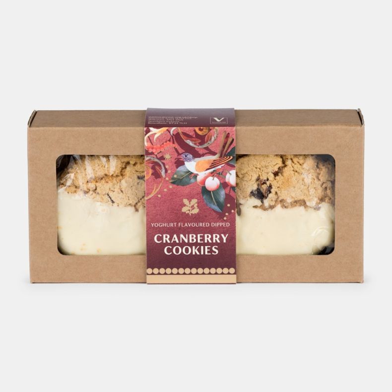 Yoghurt flavoured dipped cranberry cookies in a kraft gift carton with viewing windows and a festive illustrated sleeve featuring a bird, cherries and seasonal botanical details, shown front on.