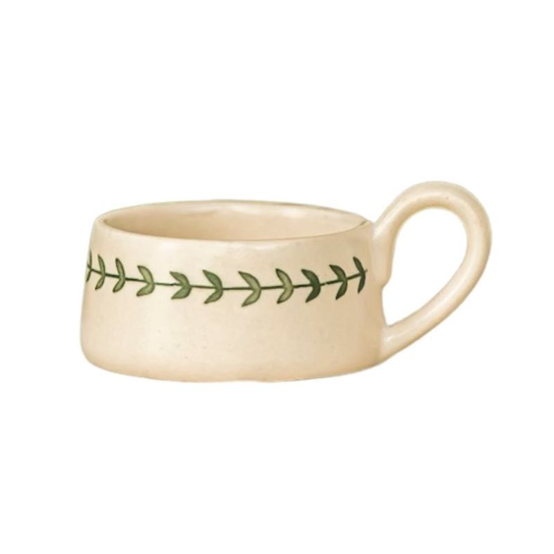 Hand-painted ceramic tealight holder with a rounded loop handle, featuring a cream glazed finish and a delicate green wreath-inspired leaf border around the exterior, designed to hold a single tealight candle.