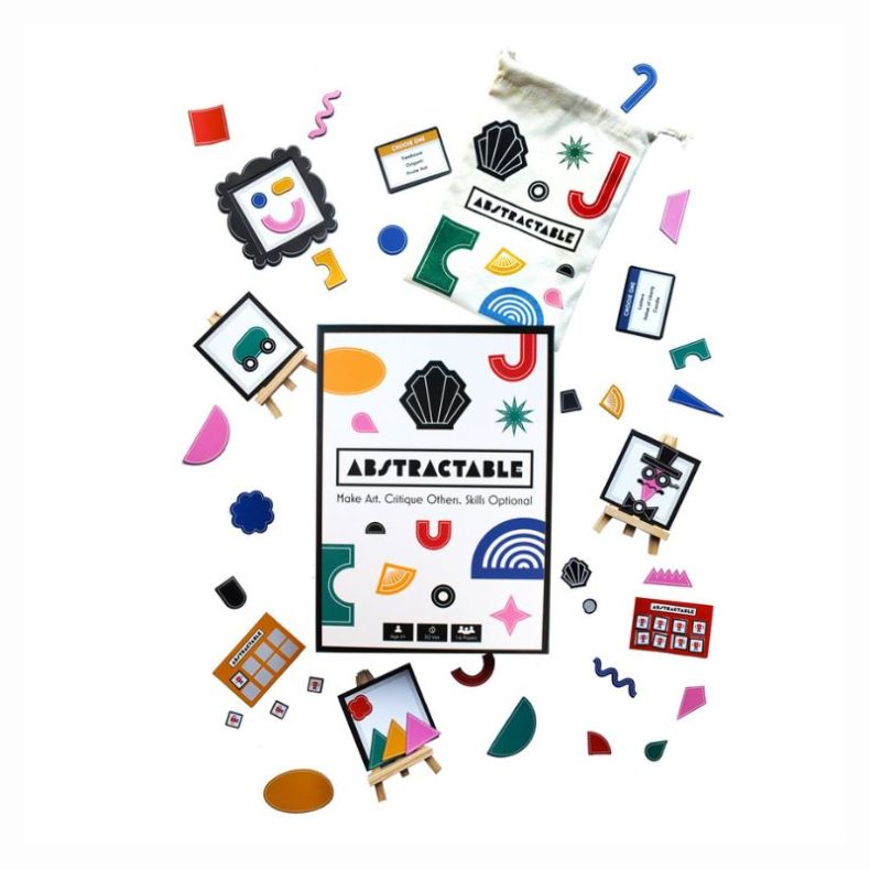 Abstractable game contents displayed around the game box, including colourful geometric shape pieces, drawstring storage bag, challenge cards and miniature easels with abstract creations. Components are arranged on a white background.
