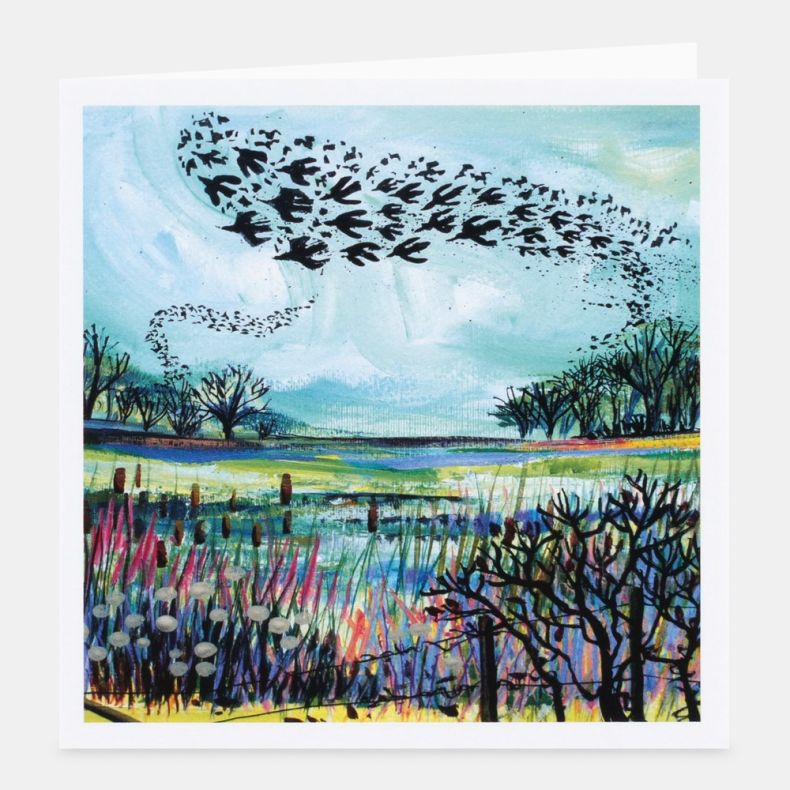 Landscape-themed notecard featuring colourful artwork of a wetland scene with a large flock of birds flying in formation across a pale blue sky, above reed beds, water and winter trees, displayed with a white border and matching envelope on a white backgr