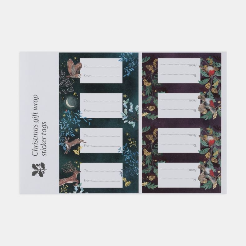Sheet of eight Christmas gift tag stickers featuring two coordinating festive designs, including a woodland scene with a stag, hare, owl, stars and crescent moon on a deep blue background, and a robin-and-acorn pattern on a rich burgundy background. Each 