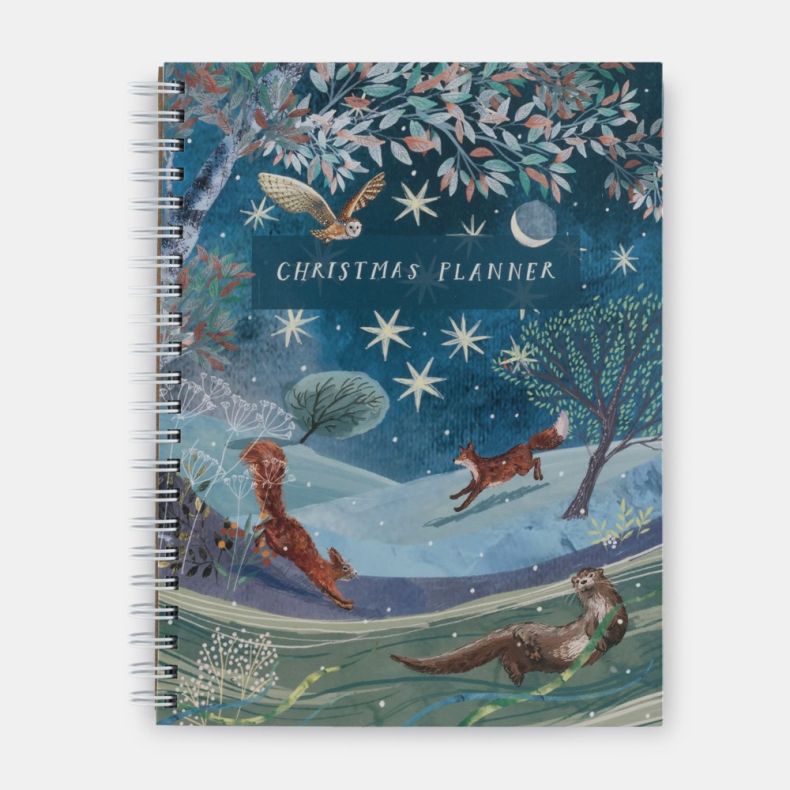 National Trust Christmas Planner spiral-bound notebook featuring a winter wildlife illustration with an owl in flight, a fox, a squirrel and an otter in a snowy countryside landscape beneath a star-filled night sky and crescent moon, with “Christmas Plann