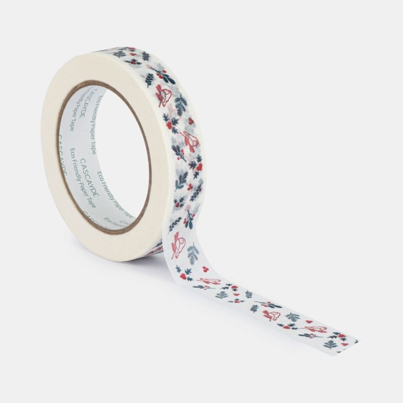 Roll of eco-friendly paper tape shown from an angled view with a length partially unrolled, featuring a festive winter pattern of red songbirds, holly leaves, berries, pine sprigs and foliage printed on a white background, isolated on a white background.
