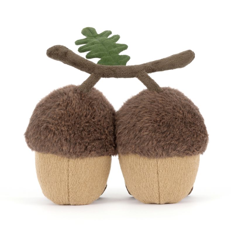 Jellycat acorn soft toy shown from the back, featuring two plush acorns joined by a soft brown branch with a green oak leaf. The cuddly design has fluffy brown caps, tan textured bodies and a woodland-inspired appearance.