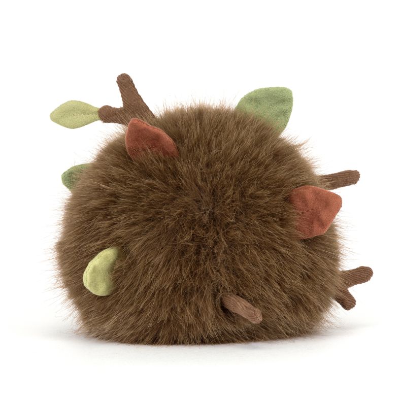 Jellycat soft toy shown from the back, featuring fluffy brown faux fur with soft fabric leaves and branch details tucked throughout. The woodland-inspired plush has a round shape with textured, nature-themed accents.