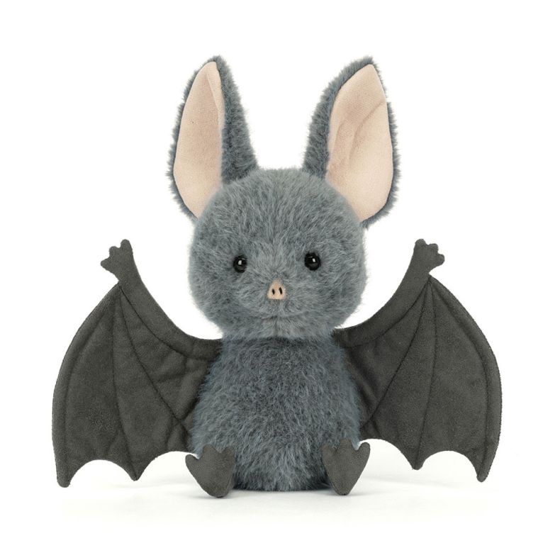 Grey fluffy bat plush toy with large cream-lined ears, outstretched dark grey wings, and small feet, photographed against a light grey background.