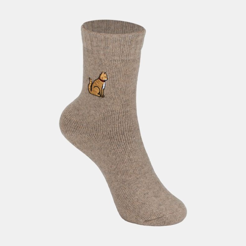 Light brown ankle sock with a soft marl texture and ribbed cuff, featuring an embroidered golden dog motif with a red collar on the outer ankle, displayed against a white background.