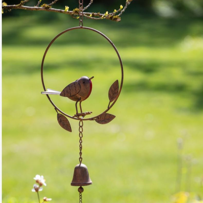 Metal robin wind chime with an antique copper-effect finish, featuring a sculpted robin with a red breast perched within a circular frame accented by decorative leaf details, suspended above a hanging bell and metal chime ornament, displayed outdoors hang