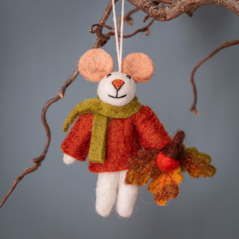 Felt hanging mouse ornament wearing an orange jumper and green scarf, holding an autumn oak leaf with an acorn detail, suspended by a natural hanging loop and displayed on a decorative branch.