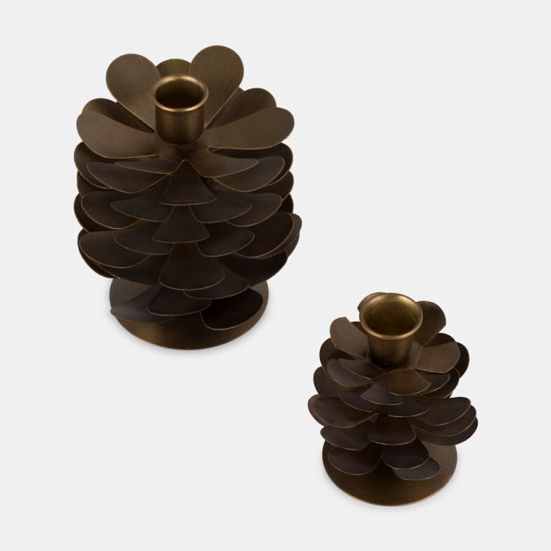 Set of two pine cone-inspired metal candle holders in an antique gold finish. Featuring layered petal-like metal details and integrated candle cups, the holders are displayed in two sizes from an elevated angle against a plain light grey background.