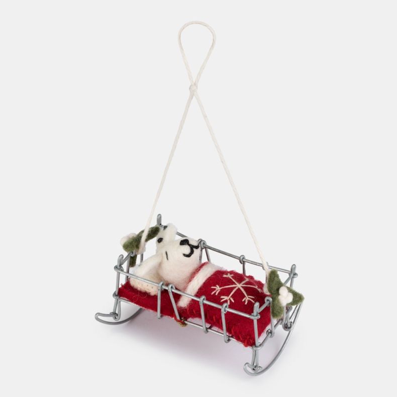 Felt Dalmatian puppy Christmas hanging decoration in a miniature silver-tone wire bed, featuring a white wool-effect puppy with black spots, embroidered facial details, a red felt blanket with white snowflake embroidery, holly accents, and a natural hangi