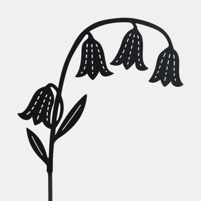 Close-up of decorative black metal garden stake featuring drooping bellflower silhouettes with cut-out detailing and leaf accents on a curved stem