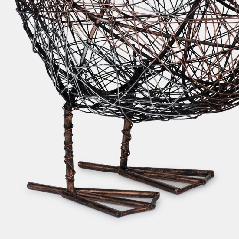 Close-up of decorative wire bird sculpture showing the openwork metal body and handcrafted wire feet in a rustic brown finish