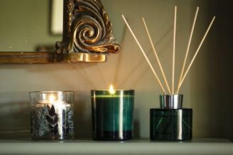 Home fragrance - image shows the Coffee and Bergamot Reed Diffuser on a windowsill, with a soft light shining through the window and illuminating the retro, vintage inspired glass bottle.