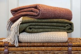 Throws & blankets - image shows the Jacquard Leaves Throw paired with the Illusion Red Throw on a windowsill, with pampas grass adding a natural touch to the home decor.